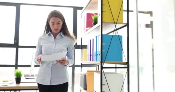 女性会計責任者またはCeoは 文書を注意深く見て オフィスを歩いています 財務諸表 事業文書の研究 — ストック動画