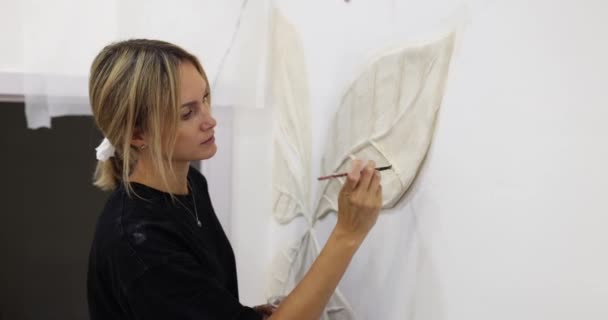 壁にスタッコとベースリリーフを彫刻するプロセス 女性のマスターデザイナーは壁にリプタを描きます — ストック動画
