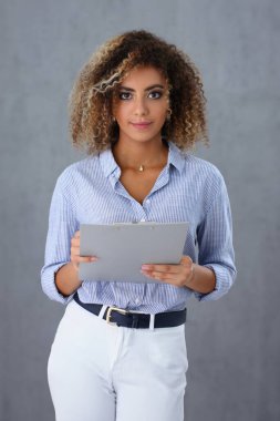 Beautiful portrait of black hispanic woman holding clipboard with business documents. Marketer with financial statistics report