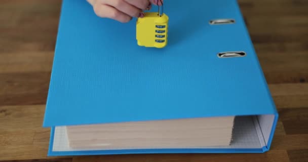 Mão Pessoa Coloca Cadeado Código Amarelo Pasta Azul Com Papelada — Vídeo de Stock