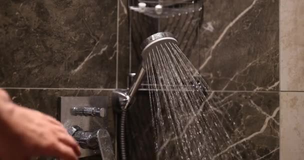 在浴室的淋浴间壁上 水从结扎在墙上的凉水里喷出 女人用强大的水柱关掉水龙头 — 图库视频影像
