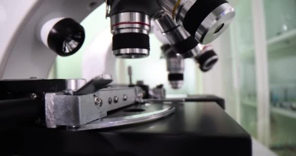 診療所の専門の実験室のテストのための顕微鏡 ラボオフィスの専門の実験室のテストのためのさまざまな目が付いている顕微鏡 — ストック動画