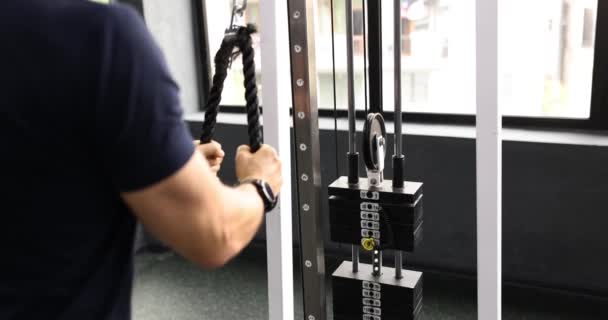 运动员在健身中心的举重机上进行力量锻炼 男子在度假健身馆慢动作锻炼过程中的活力测试 — 图库视频影像
