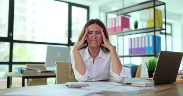 在办公桌前的笔记本电脑前工作的年轻灰心丧气的女人 每天都患有慢性头痛 工作中的过度工作压力和偏头痛 — 图库视频影像