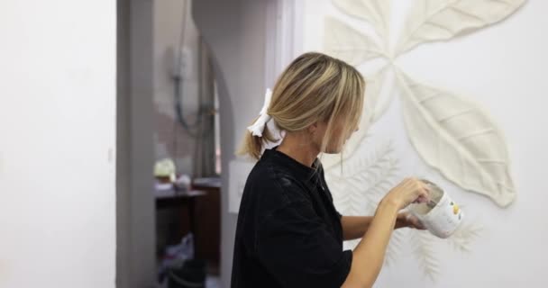 壁にスタッコとベースリリーフを彫刻するプロセス プラスターの瓶を保持する女性のマスター — ストック動画