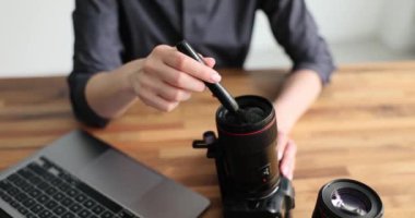 Fotoğrafçı elleri kameranın lenslerini fırçayla siliyor. 4K yakın çekim filmi yavaş çekim. Fotoğraf ekipmanları konseptinin bakımı ve bakımı
