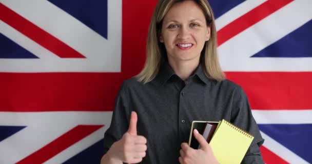拿着英语教材 在英国国旗4K电影慢动作背景下大显身手的女人 外语学校概念 — 图库视频影像