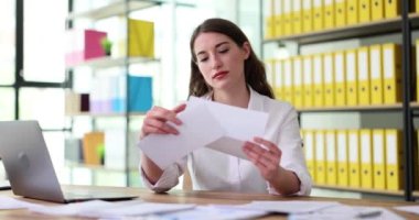 Şaşırmış kadın zarfı açıyor ve 4K film yavaş çekimde üzülüyor. Vergi bildirimi posta kavramı