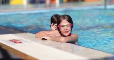 Okul 4K filminde havuz kenarındaki yüzme gözlüklü çocuklar ağır çekimde. Çocuk konsepti için sağlıklı yaşam tarzı ve spor
