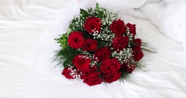 Kırmızı güller ve beyaz çiçeklerle dolu bir buket 4K film. Evlilik yıldönümü konsepti