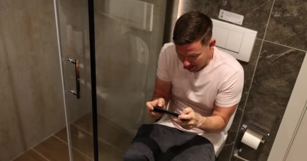Homem Sentado Banheiro Jogando Jogo Computador Telefone Celular Filme Conceito — Vídeo de Stock