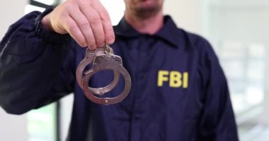 FBI çalışanları ellerinde kelepçelerle 4K 'lık filmi yavaş çekimde çekiyorlar. Suçların ve cinayetlerin soruşturulması ve cezai sorumluluk kavramı