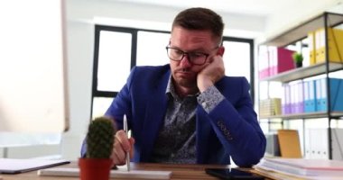 Sıkıcı iş adamı ofiste bilgisayar klavyesinde 4K kalemle yazı yazıyor. İş konseptinde tembellik