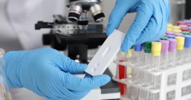 Laboratuvar 4K filminde mikroskop önünde sonuç Coronavirus testini değerlendiren doktor. Diagnostik covid-19 konsepti