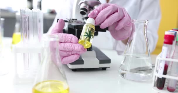 Scientist Chemist Gloves Holding Vial Marijuana Oil Front Microscope Laboratory — ストック動画