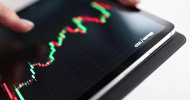 Borsa tabletinin tabletini elinde tutuyor. Yatırım alım-satım konsepti