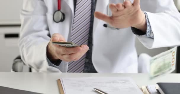 白いコートの医者はそれらを散乱している間ドル札を数える 最高の有料医療職業概念 — ストック動画