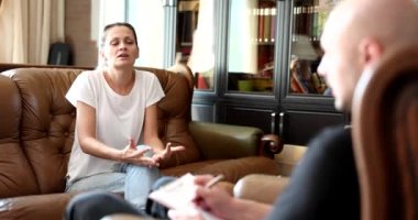 Stresli bir kadın terapi seansında psikologla konuşuyor. Psikoloji ve terapi kavramı