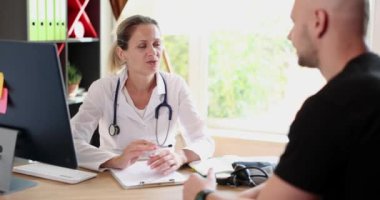 Terapist doktor klinikteki erkek hastalarla iletişim kuruyor. Doktor hastayı muayene etmeye ve yardım etmeye hazır.