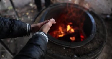 Evsiz ellerin yakını kendini ateşle ısıtıyor. Yoksulluk kavramı insanın sıcaklığı ya da kendini ateşle ısıtan bir turist.