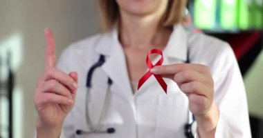 HIV ve AIDS gününün doktor eli sembolü kırmızı kurdele. HIV enfeksiyonu ve tedavisi komplikasyonları