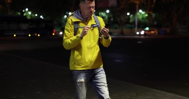 男人走在晚上看着手机与严重的脸和抱着头在恐慌 负面情绪坏消息或忧郁症 — 图库视频影像