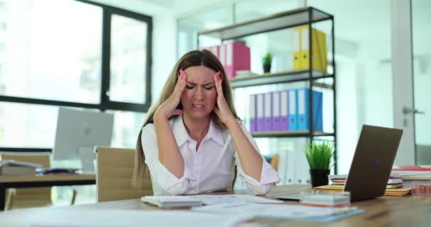 慢性的な頭痛と若い疲労した女性は 仕事で片頭痛に苦しんでいます 寺院に触れるマネージャーと痛みを和らげる — ストック動画