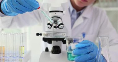 Bilimadamı laboratuvar görüntülerine mikroskop ile petri kabı bırakıyor. Zehirli sıvılar üzerine çalışmalar