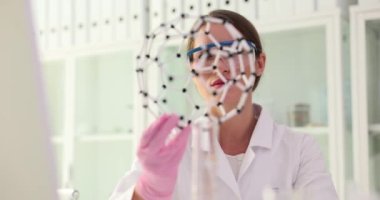 Bilim adamı moleküler yapının modeline bakıyor. DNA moleküler modelleri