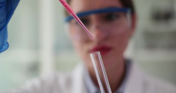 ピペットから透明なガラス試験管への赤い液体ドロップ 実験室での血液サンプル分析と研究のドリッピング — ストック動画
