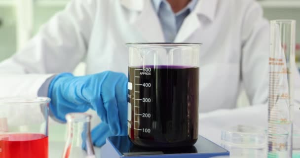 实验室里装有沸腾的黑色溶液的科学家瓶 磁力搅拌器移动有毒溶液并将其煮沸 — 图库视频影像