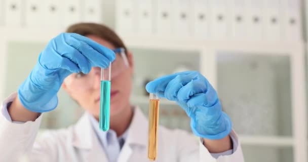 Científico Sostiene Dos Tubos Ensayo Con Líquido Amarillo Azul Laboratorio — Vídeos de Stock