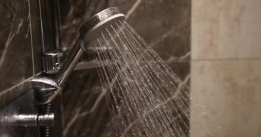 Banyodaki duş musluğundan akan su telleri. Duş musluğundan akan su