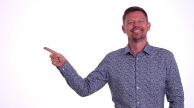 Gülümsemek beyaz arka planda boş alan ve boş uzayda noktalar önerir. Baş parmağını kullanan ve reklam için en iyi seçim tabelalarını kullanan bir adam.