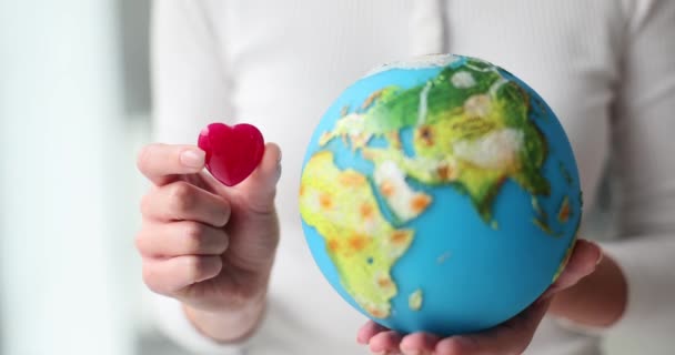 Woman Holding Globe Red Heart Closeup Volunteer World Aid — Stock Video