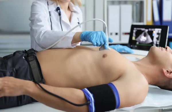 Portrait of doctor investigating male body, medical worker watch on screen with live picture. Person on planned checkup in hospital. Ultrasound concept