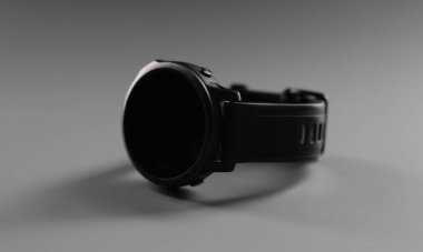 Moda minimalist cihazın yakın çekimi, gri arka planda uzanan siyah erkek kol saati. Dijital kadranlı Gadget, gösteri zamanı. Teknoloji, zaman kavramını izle