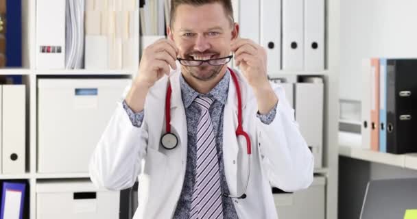 Sonriente Médico Joven Que Pone Gafas Lugar Trabajo Clínica Concepto — Vídeo de stock