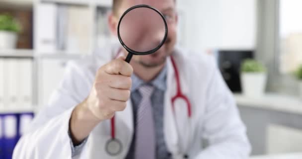 Leende Manlig Läkare Tittar Genom Förstoringsglas Begreppet Medicinsk Diagnos — Stockvideo