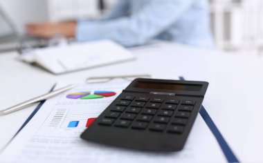 Siyah hesap makinesi bir satranç tahtası üzerinde yatıyor. İş stratejisi hesaplama hesaplamak için arka plan.