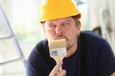 Gülümseyen alt kolu fırça portre tut. El ile iş işyeri DIY ilham geliştirme tamir dükkanı sarı kask kask sanayi başlangıç fikir endüstriyel eğitim meslek kariyer kavramı