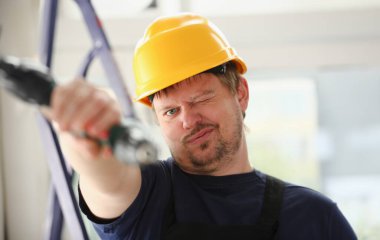 Elektrikli matkap closeup kullanarak alt kollarından. El ile iş DIY ilham geliştirme tamir dükkanı sarı kask sanayi başlangıç fikir endüstriyel eğitim meslek kariyer kavramı