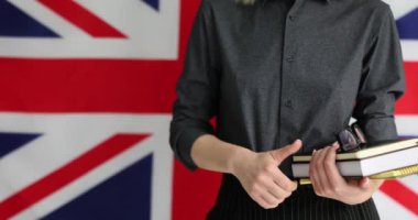 Bayan İngilizce öğretmeni ya da öğrenci İngiliz bayrağına başparmak işareti gösteriyor. Londra 'da Eğitim