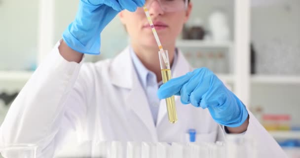 手袋の科学者は 微生物学の実験室でフィンストリップに関する研究を行っています 液体の酸性をテストする — ストック動画