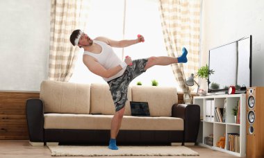 Yakışıklı delikanlı şort ve yelek pembe dumbbells elinde tutar. Tek mücadele resepsiyonlar sensei bir ev fitness kapalı eğitim bağımsız eğitim uzaktan pratik tv ders izle