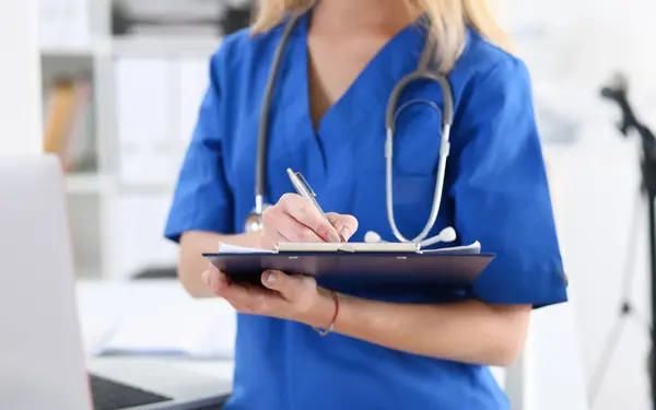 Female medicine doctor hand holding silver pen looking in clipboard pad closeup. Ward round patient visit check 911 medical calculation and statistics concept. Physician ready to examine patient