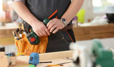 Elektrikli matkap closeup kullanarak alt kollarından. El ile iş DIY ilham iyileştirme iş tamir dükkanı sarı kask sanayi başlangıç fikir endüstriyel eğitim meslek kariyer kavramı