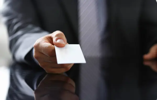 Male arm in suit give blank calling card to visitor closeup. White collar colleagues company name exchange job interview sale clerk id, executive or ceo finance support formal identity concept