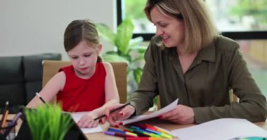 Güzel bir kadın ve sevimli bir kız çocuğu renkli kalemlerle albüm çiziyorlar. Sevgi dolu anne çocuğunu geliştirir ve sohbetten zevk alır.