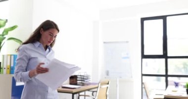 Ofiste belgeleri okuyan genç ve güzel bir iş kadını. İş belgeleri inceleniyor